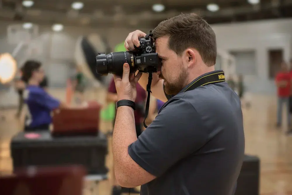 Grads photographer at work in a school gym
