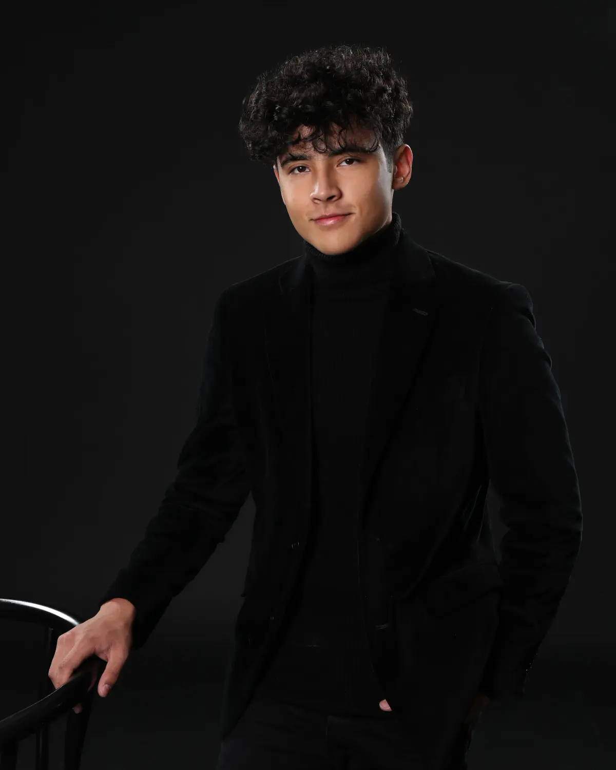 Senior portrait in the studio against a black backdrop