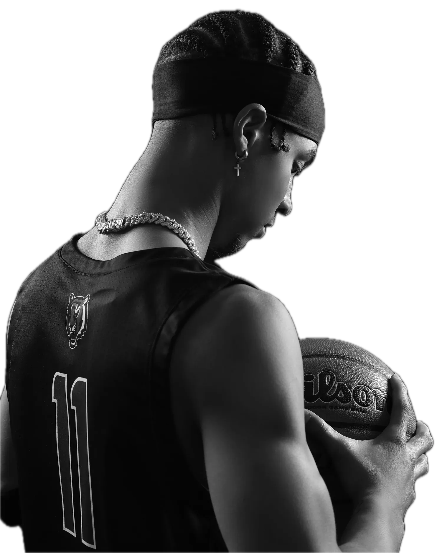 Basketball player in black and white, head bowed, holding the ball