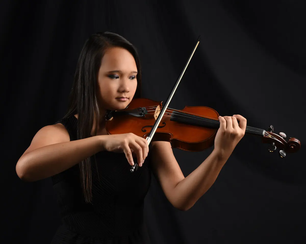 Senior portrait with her violin on a black backdrop