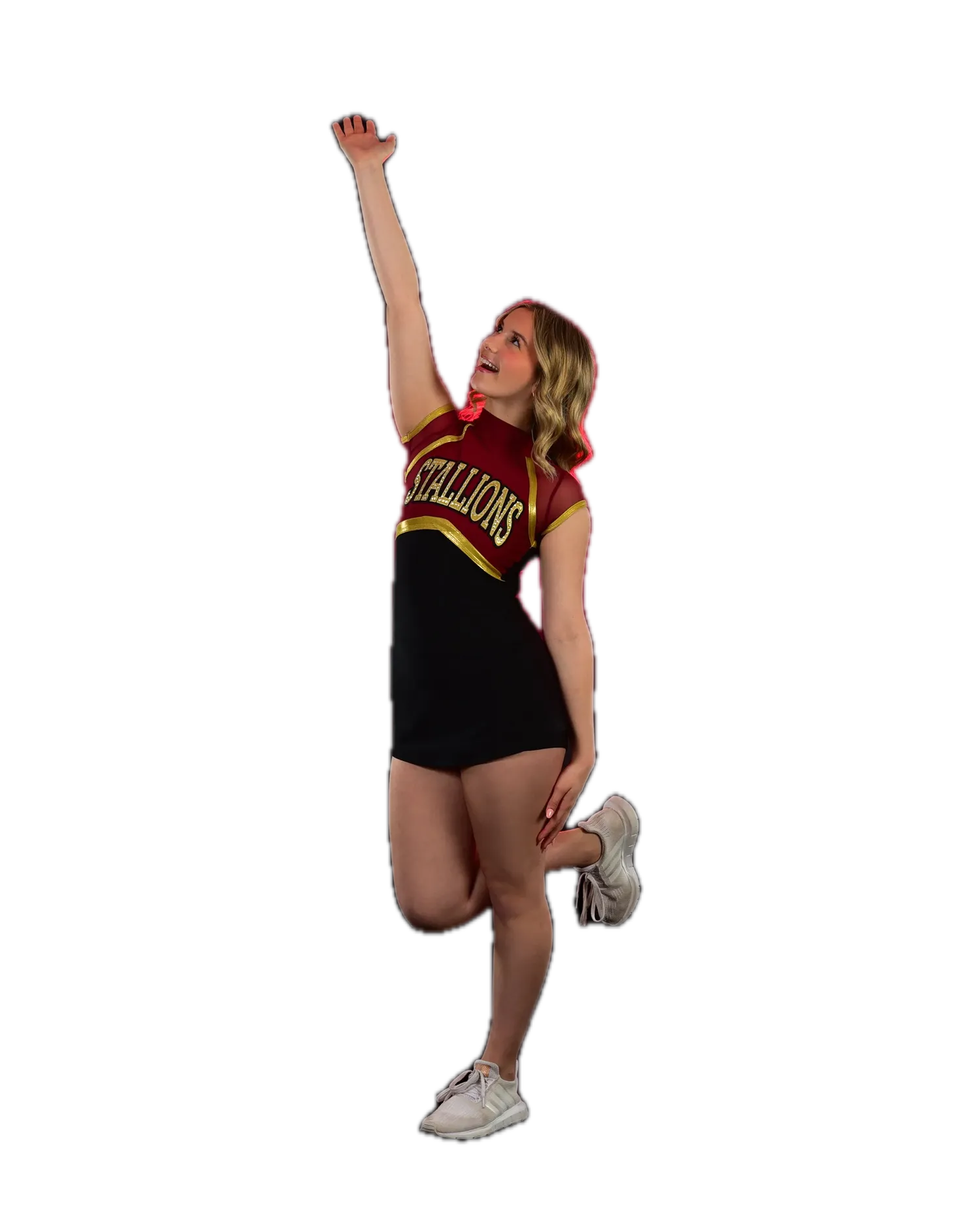 Cheer/pom athlete in a maroon/black uniform with gold-sequin 'STALLIONS' lettering, one arm reaching up, one leg kicked back, smiling upward