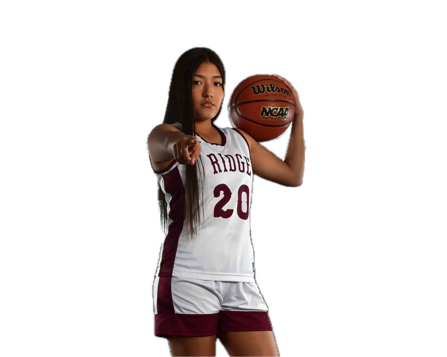 Female basketball player in a white and maroon jersey (#20, team name visible) pointing at the camera, a ball held on her shoulder
