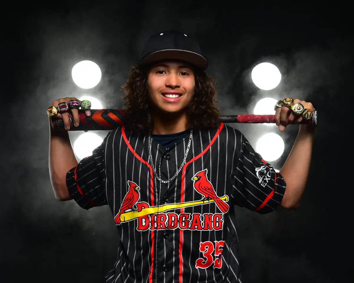 Smiling baseball player with bat across his shoulders, championship rings on several fingers, chain necklace, 'Birdgang 35' pinstripe jersey